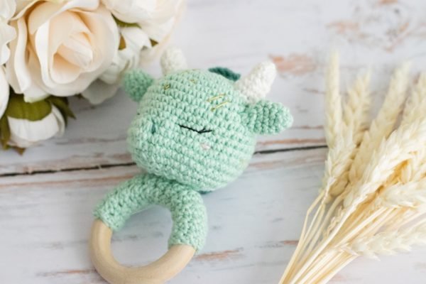 Hochet dragon vert en crochet avec yeux dormeurs et anneau de dentition en bois.