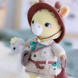 Indy la Girafe Exploratrice, amigurumi au crochet avec tenue d'aventurière, chapeau safari, lanterne lumineuse, sacoche, bandana et doudou éléphant